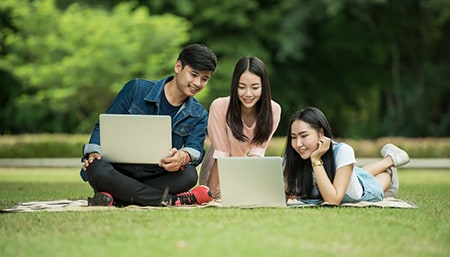 Students on laptops outside